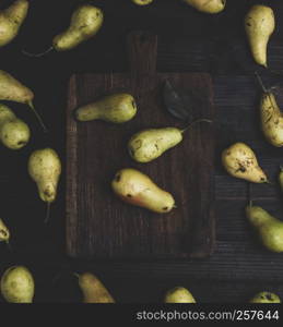 fresh ripe yellow pears on a brown wooden table, top view
