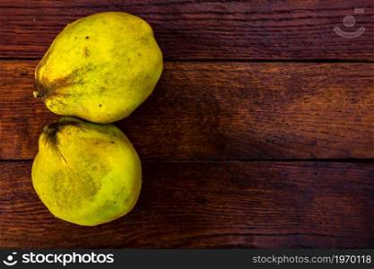 Fresh ripe yellow quince. Fruits in a wooden table