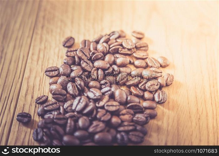 Fresh roasted coffee beans on wooden table, background texture