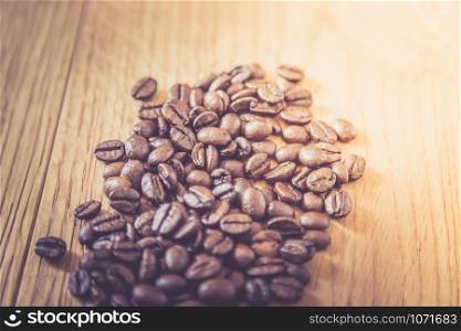 Fresh roasted coffee beans on wooden table, background texture