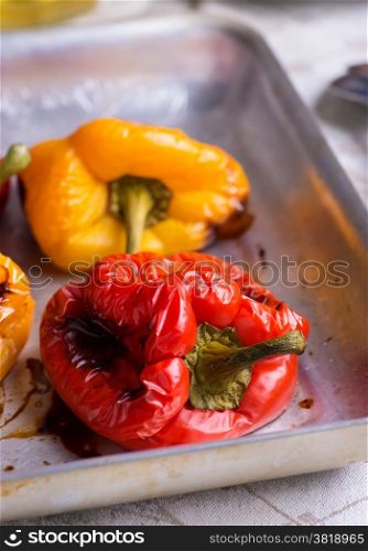Fresh roasted red and yellow peppers on metal tray, closeup, selective focus