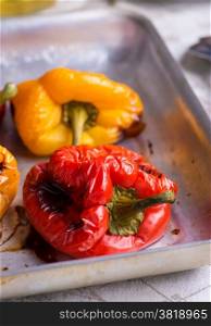 Fresh roasted red and yellow peppers on metal tray, closeup, selective focus