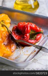 Fresh roasted red and yellow peppers on metal tray, selective focus