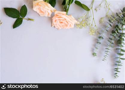 fresh rose flowers. Rose flowers and green leaves on blue table from above with copy space