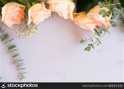 fresh rose flowers. Rose flowers row with green leaves on blue table from above with copy space