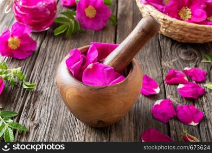 Fresh Rugosa rose petals in a wooden mortar