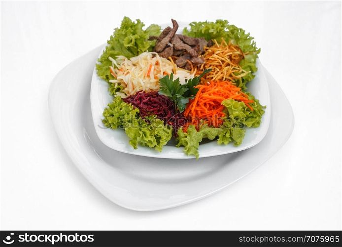 fresh salad. Fresh vegetable salad with slices of meat, filmed on a sheet of white plastic, close-up