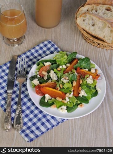 Fresh salad mix with persimmons, feta cheese and peanuts
