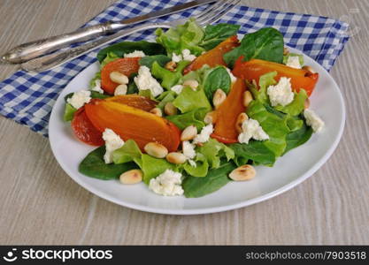 Fresh salad mix with persimmons, feta cheese and peanuts