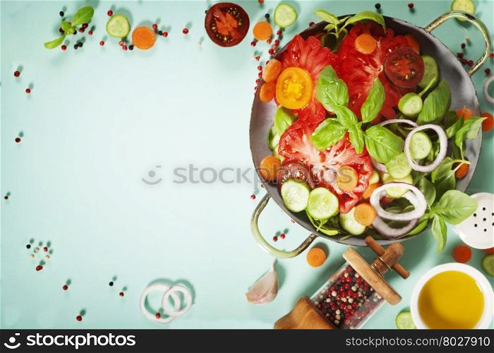 Fresh salad on blue background - Tomatoes, onion, carrot, basil, cucumbers, salt and pepper. Top view