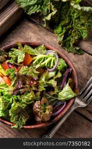 Fresh salad plate with mixed greens.Rhubarb salad.Vegetarian spring salad. Spring salad on wooden background