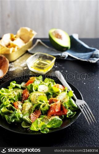 Fresh salad with avocado, cucumber, salmon. Dressing with honey, dijon mustard, olive oil and lemon juice