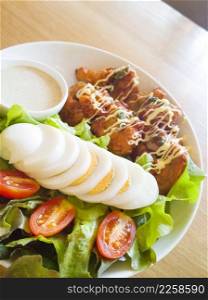 Fresh salad with chicken breast,lettuce and tomatoes on wooden table