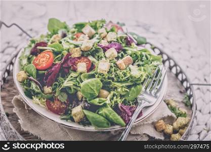 Fresh salad with croutons, tomatoes and olives