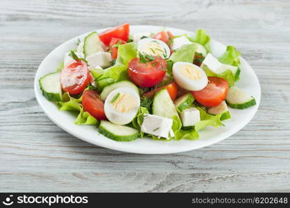 Fresh salad with quail eggs, cherry tomato, cucumber and lettuce