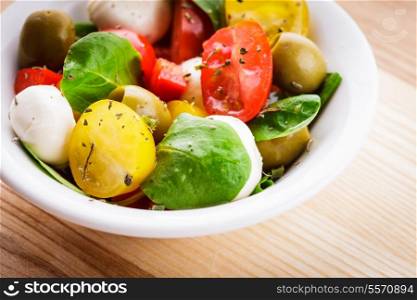Fresh salad with tomatoes, olives and mozzarella with spices