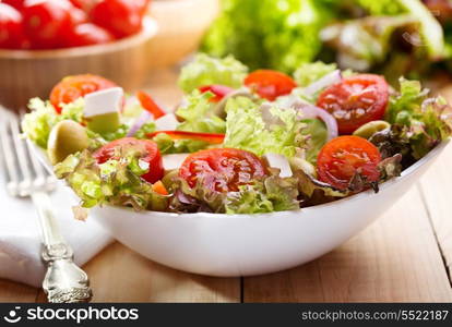 fresh salad with vegetables and greens on wooden table