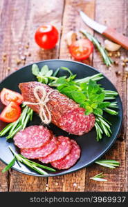 fresh salami on plate and on a table