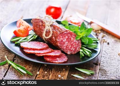 fresh salami on plate and on a table