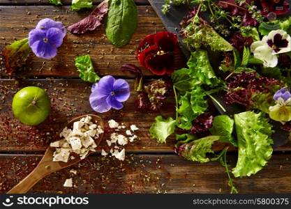 Fresh saland ingredients lettuce flowers spinach feta cheese on rustic wood