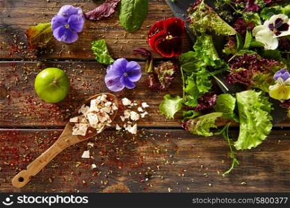 Fresh saland ingredients lettuce flowers spinach feta cheese on rustic wood