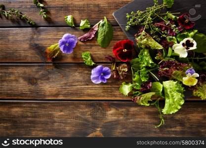 Fresh saland ingredients lettuce flowers spinach on rustic wood
