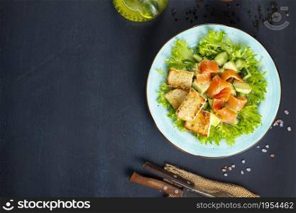 fresh salmon fish with green lettuce and vegetables, fresh salad with greens, salmon and croutons