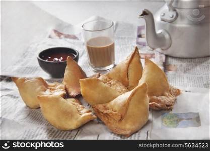 Fresh samosas with ketchup and hot chai ready for breakfast