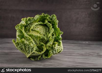 Fresh savoy cabbage closeup on grey chalkboard background.