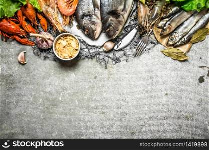 Fresh seafood. Assorted shellfish and spicy shrimp on the fishing net. On a stone background.. Assorted shellfish and spicy shrimp on the fishing net.