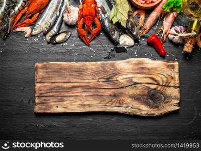 Fresh seafood. Cutting Board with a variety of shrimp, fish and shellfish. On a black chalkboard.. Cutting Board with a variety of shrimp, fish and shellfish.