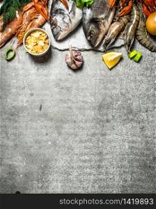 Fresh seafood. Different fish, shrimp and shellfish with slices of lemon and spices. On a stone background.. Different fish, shrimp and shellfish with slices of lemon