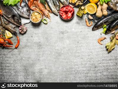 Fresh seafood. Different fish, shrimp and shellfish with slices of lemon and spices. On a stone background.. Different fish, shrimp and shellfish with slices of lemon