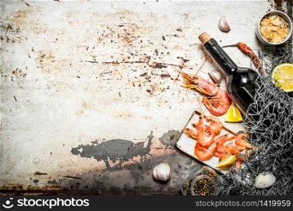 Fresh seafood. Wine with shrimp and spices with a fishing net. On rustic background .. Wine with shrimp and spices