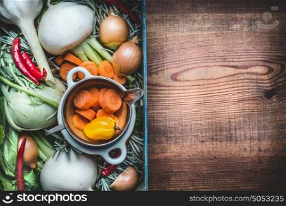 Fresh seasonal organic local vegetables box for healthy clean eating and cooking on rustic wooden background, top view, place for text. Vegan or vegetarian food concept