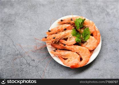 fresh shrimp on white plate with ingredients herb coriander / cooking seafood shrimps prawns served on gray table background