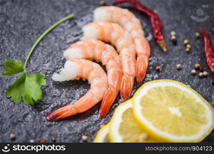 fresh shrimps served on the dark plate / boiled peeled shrimp prawns cooked with spices lemon in the seafood restaurant