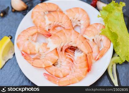 Fresh shrimps served on white plate, boiled peeled shrimp prawns cooked in the seafood restaurant - top view