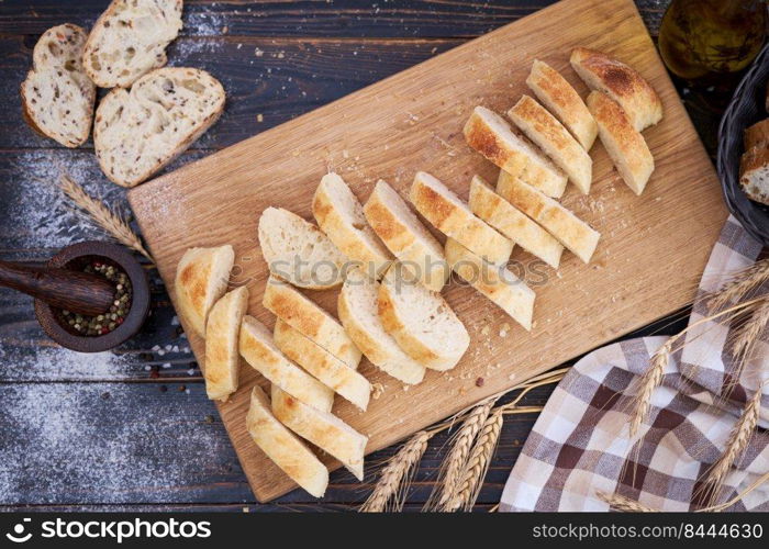 Fresh sliced bread on wooden cutting board at kitchen table.. Fresh sliced bread on wooden cutting board at kitchen table