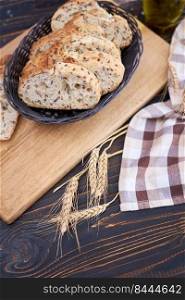Fresh sliced bread on wooden cutting board at kitchen table.. Fresh sliced bread on wooden cutting board at kitchen table