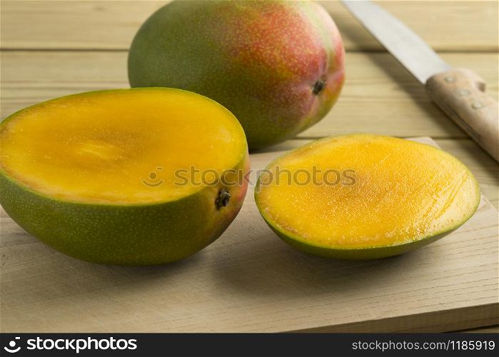Fresh sliced mango and a whole one in the backgroundwhite background