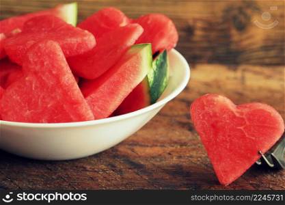 Fresh sliced watermelon on wooden background. Slices form of heart. One slice on fork .. Fresh sliced watermelon on wooden background. Slices form of heart. One slice on fork