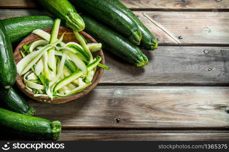 Fresh sliced zucchini in the bowl. On wooden background. Fresh sliced zucchini in the bowl.