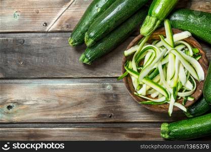 Fresh sliced zucchini in the bowl. On wooden background. Fresh sliced zucchini in the bowl.