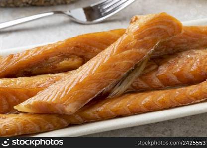 Fresh smoked salmon bellies on a plate close up