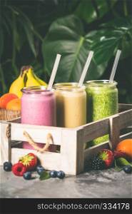 Fresh smoothies , fruits and berries on tropical leaves background. Fresh smoothies on tropical background, close up