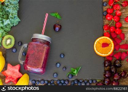 Fresh smoothy berry healthy drink in glass jar with igredients on black. Fresh smoothy berry drink