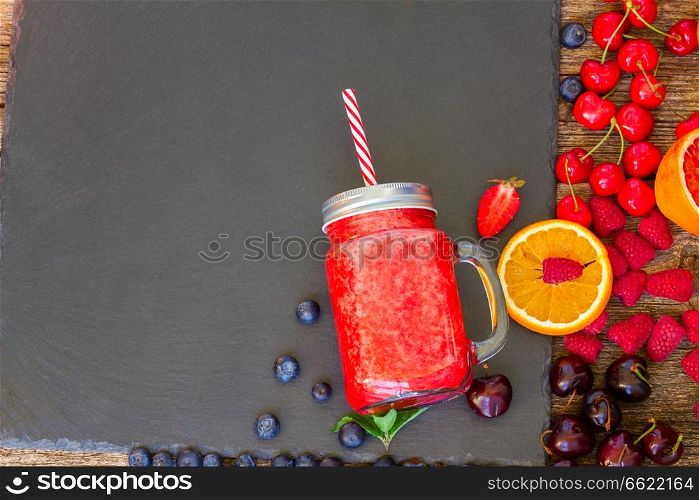 Fresh smoothy red drink in glass jar with igredients on black. Fresh smoothy red drink