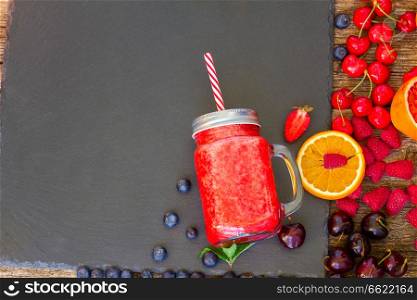 Fresh smoothy red drink in glass jar with igredients on black. Fresh smoothy red drink