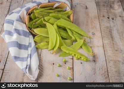 Fresh snow peas on wooden table background